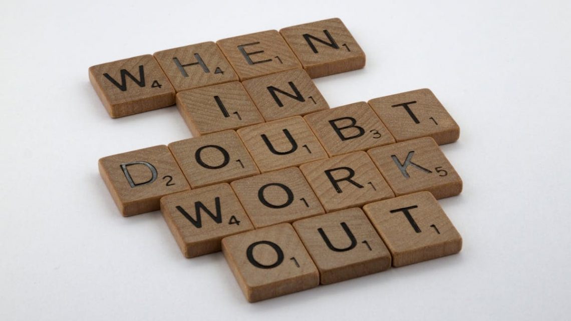 Scrabble tiles arranged to spell a motivational quote on a white background.