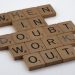 Scrabble tiles arranged to spell a motivational quote on a white background.